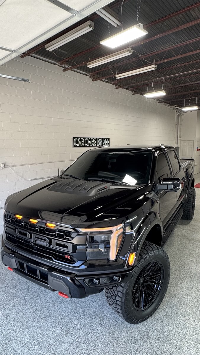 Black Ford Raptor R parked in the shop under the Car Care by Zee sign.